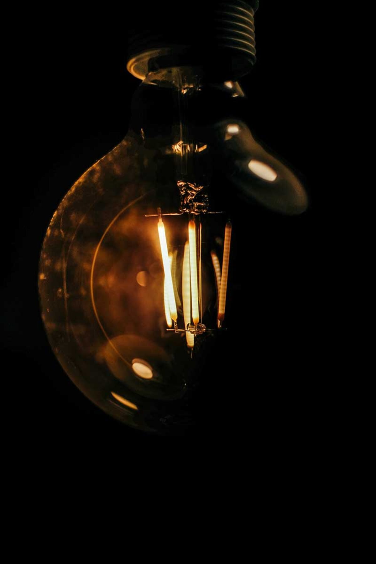 Moderne Glühbirne vor schwarzem Hintergrund
